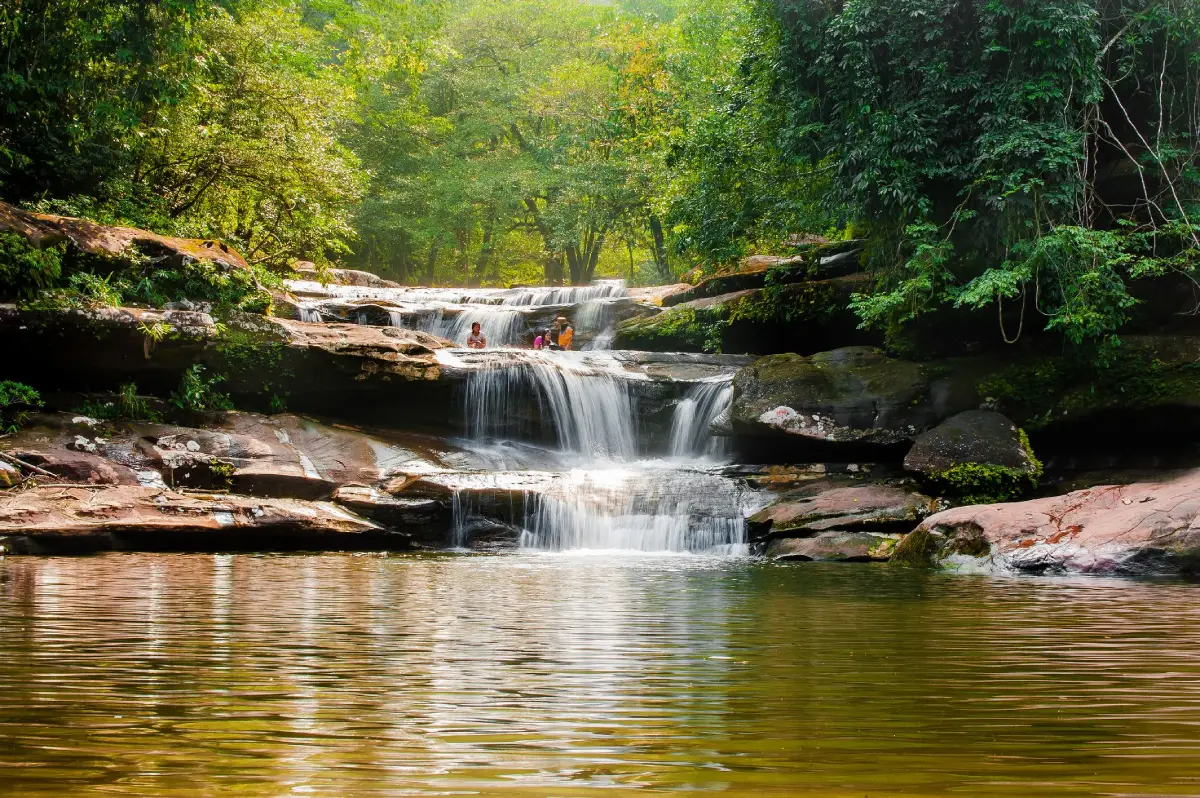 Tat Kham Waterfall in Nakhon Phanom, a forest waterfall flowing across sandstone terraces within Phu Langka National Park